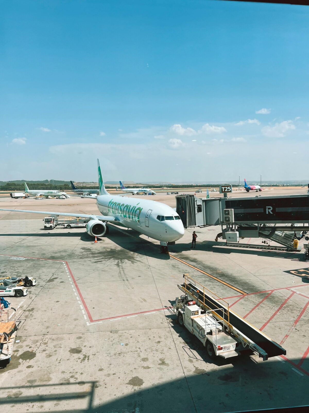 A commercial airplane parked at the airport gate under a clear blue sky.